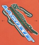 ⁦تيشرت  برتقالي مزين بشعار Lacoste⁩ - الصورة ⁦4⁩